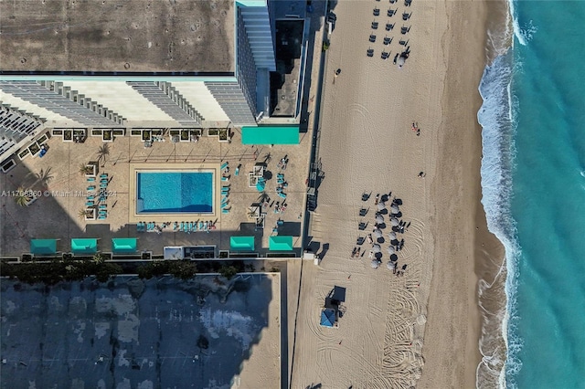 birds eye view of property featuring a beach view and a water view