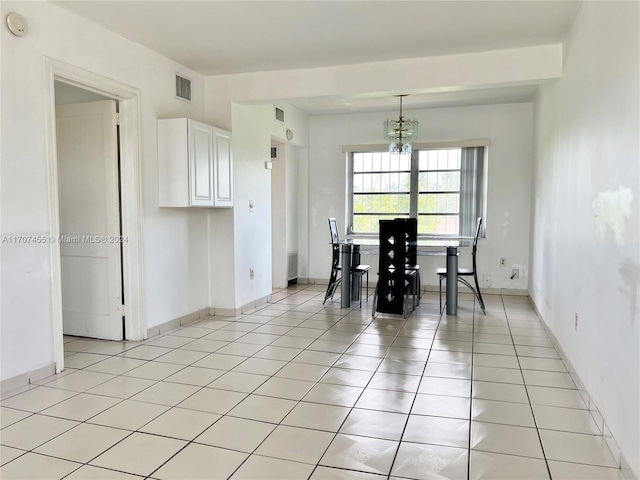 unfurnished dining area featuring light tile patterned floors and a notable chandelier