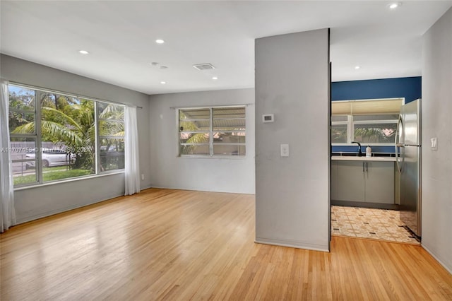 empty room featuring light wood-type flooring and sink