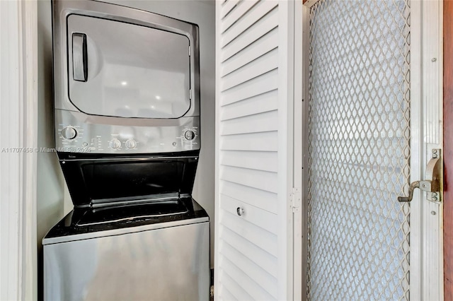 washroom featuring stacked washer and clothes dryer