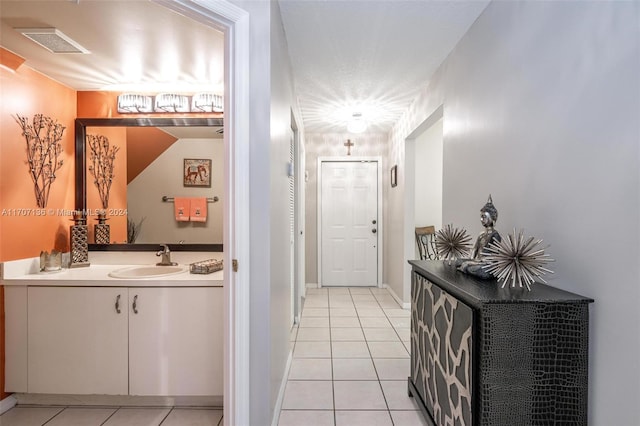 corridor with light tile patterned flooring and sink