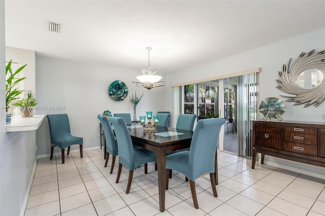 dining area featuring light tile patterned floors and a textured ceiling