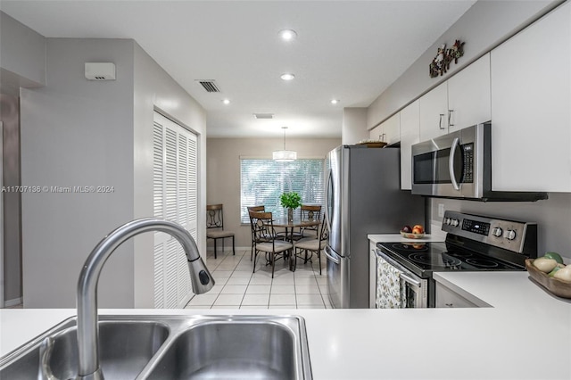 kitchen featuring sink, hanging light fixtures, light tile patterned flooring, white cabinetry, and stainless steel appliances