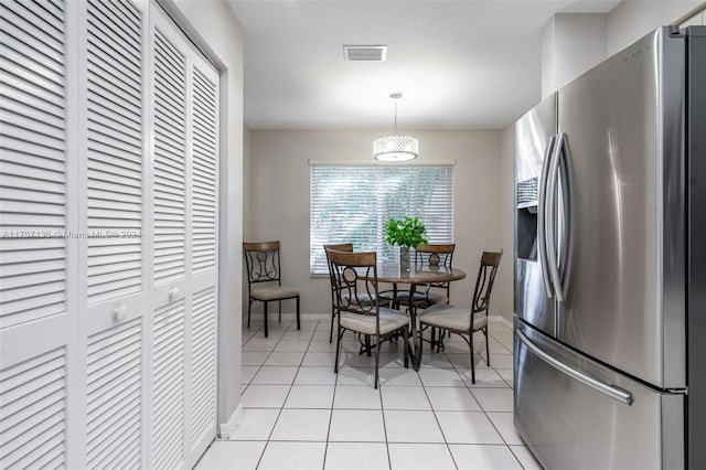 dining room with light tile patterned floors and a textured ceiling