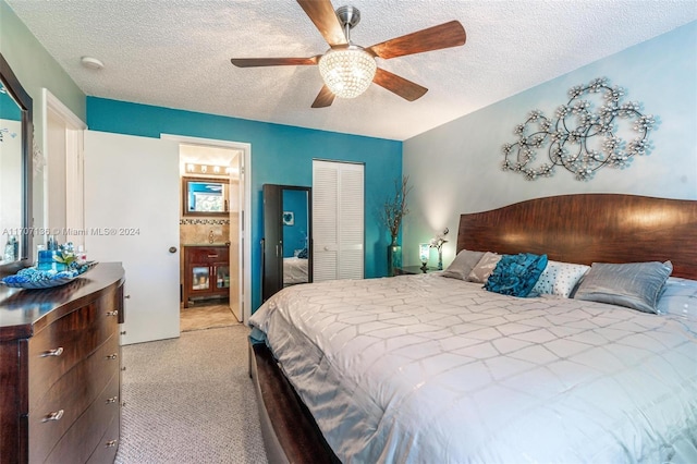 carpeted bedroom featuring a textured ceiling, a closet, ceiling fan, and connected bathroom