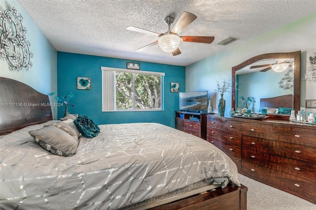 carpeted bedroom with a textured ceiling and ceiling fan