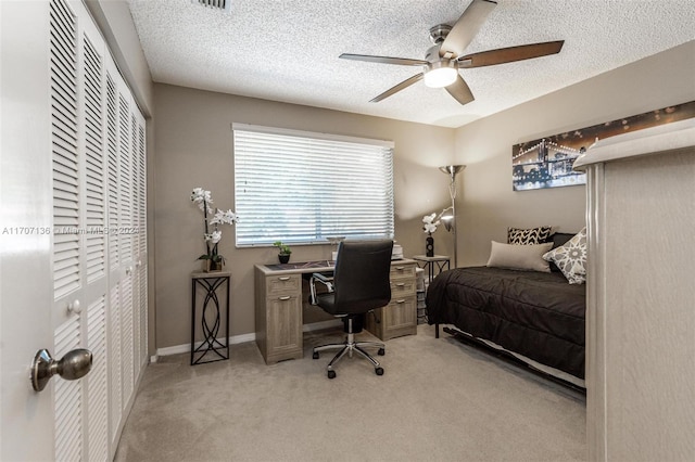 bedroom with light carpet, a textured ceiling, and ceiling fan