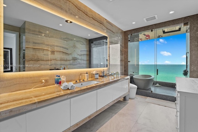 bathroom with toilet, a water view, a tub to relax in, and vanity