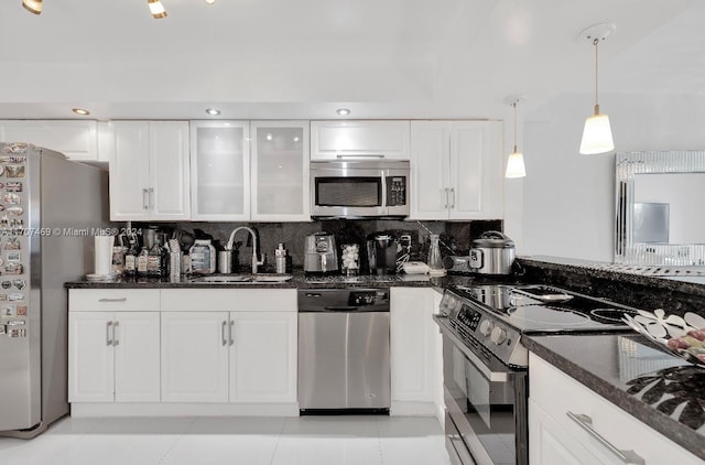 kitchen with backsplash, sink, light tile patterned floors, decorative light fixtures, and stainless steel appliances