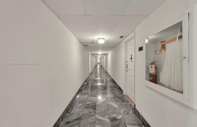 hallway featuring a paneled ceiling