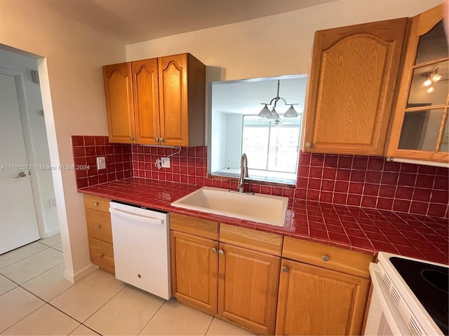 kitchen featuring backsplash, white appliances, sink, a chandelier, and tile counters