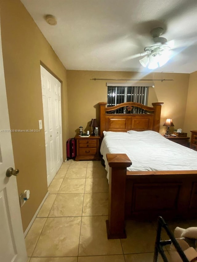 tiled bedroom with ceiling fan and a closet