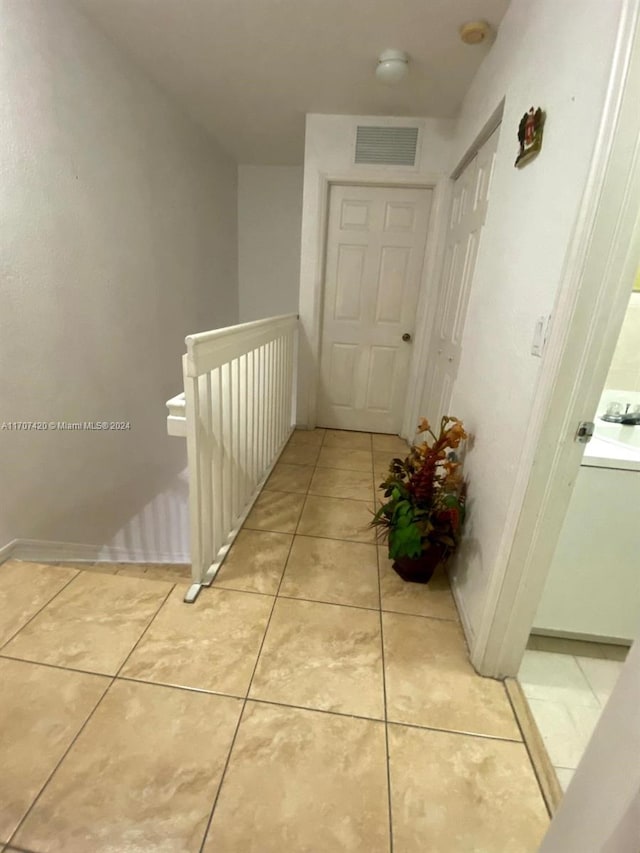 hall with light tile patterned floors