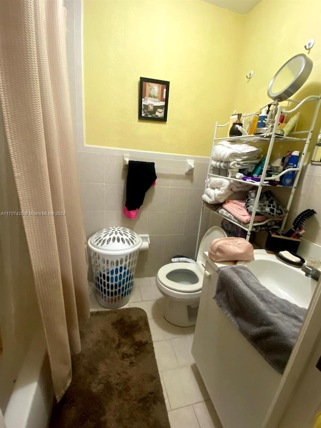 bathroom featuring tile patterned floors, toilet, tile walls, and shower / tub combo