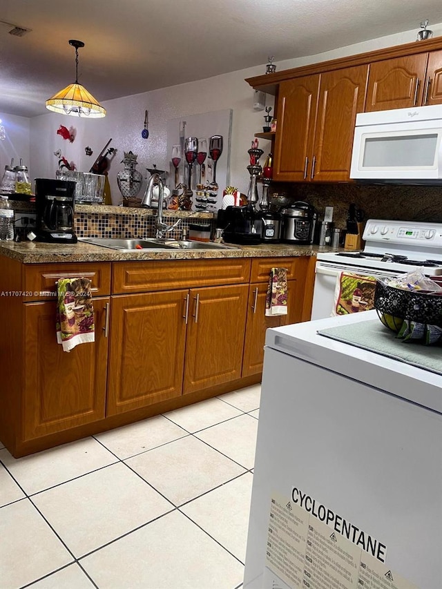 kitchen with sink, hanging light fixtures, backsplash, white appliances, and light tile patterned floors