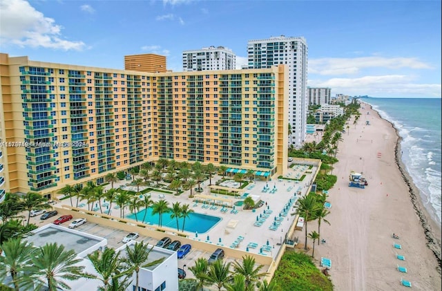 view of building exterior with a beach view and a water view