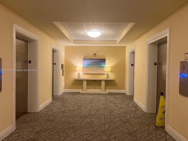 corridor with a raised ceiling and elevator