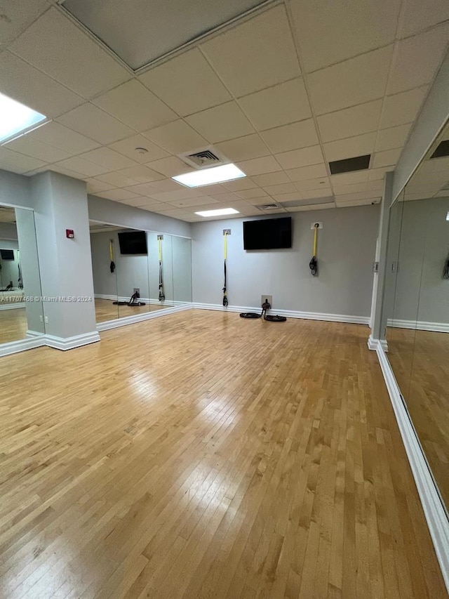 interior space with hardwood / wood-style floors and a drop ceiling