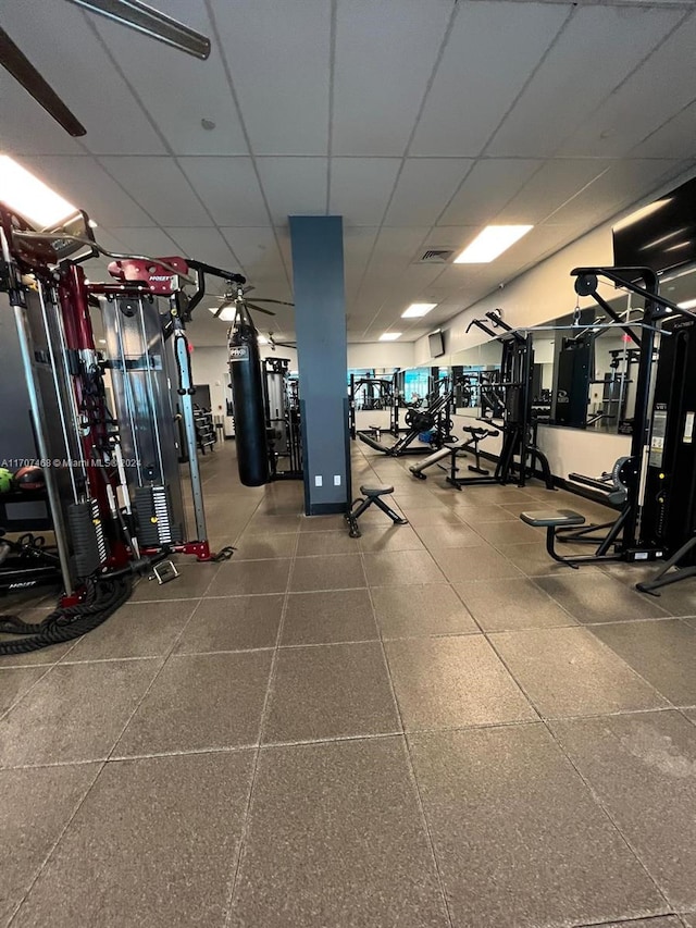 workout area featuring a paneled ceiling and ceiling fan