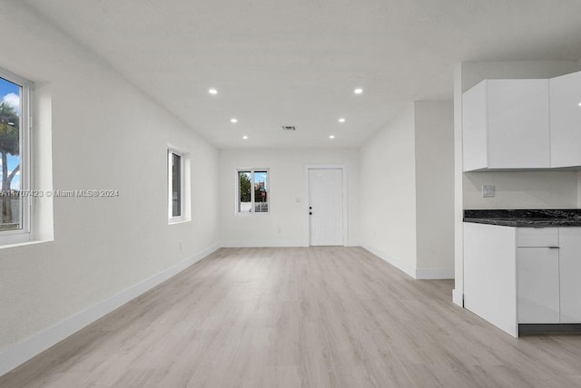 unfurnished living room with light wood-type flooring and a wealth of natural light