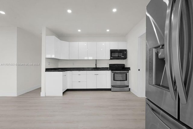 kitchen with white cabinetry, appliances with stainless steel finishes, and light hardwood / wood-style flooring