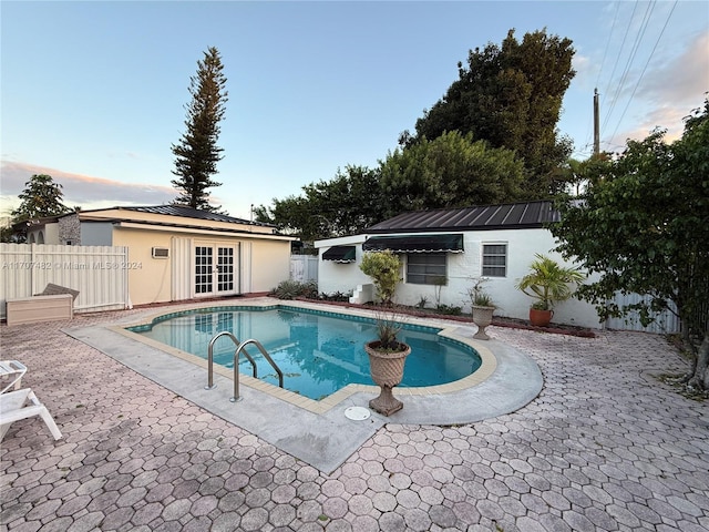 view of swimming pool with a patio area and french doors