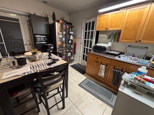 kitchen featuring stainless steel refrigerator and light tile patterned flooring