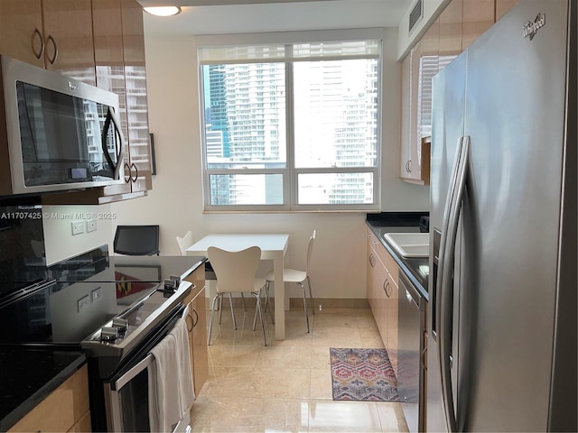 kitchen with dark countertops, visible vents, appliances with stainless steel finishes, and baseboards