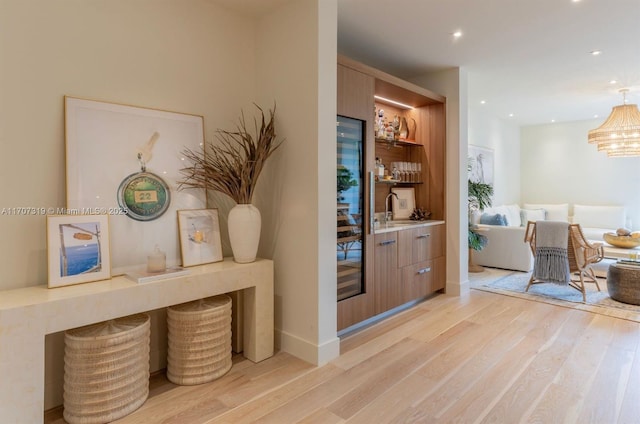 interior space with a sink, baseboards, recessed lighting, and light wood-style floors