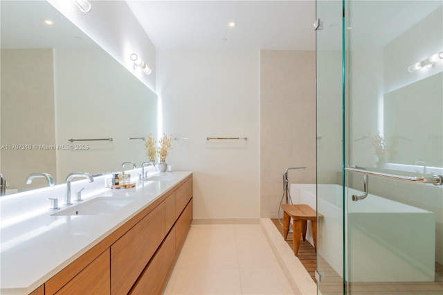 bathroom featuring tile patterned floors, double vanity, a sink, and a soaking tub