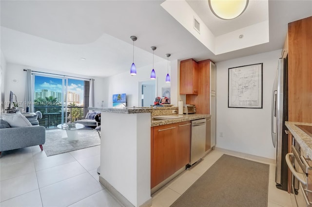 kitchen with kitchen peninsula, light tile patterned floors, decorative light fixtures, and appliances with stainless steel finishes