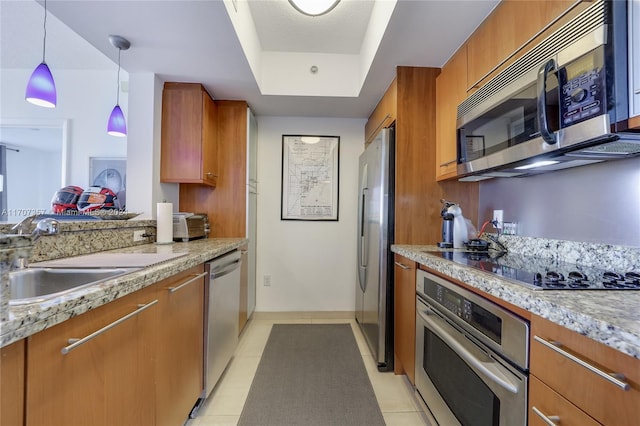 kitchen featuring light stone countertops, sink, hanging light fixtures, light tile patterned floors, and appliances with stainless steel finishes