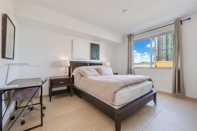 bedroom with light tile patterned floors and a textured ceiling