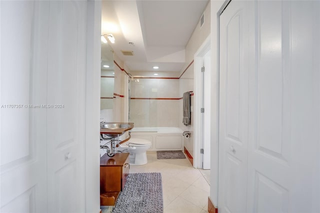 full bathroom featuring tile patterned floors, tiled shower / bath combo, toilet, and sink