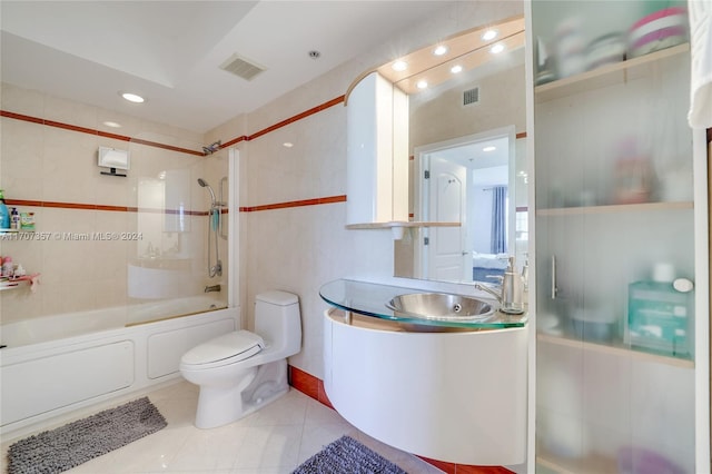 full bathroom with tile patterned flooring, tiled shower / bath combo, toilet, and vanity