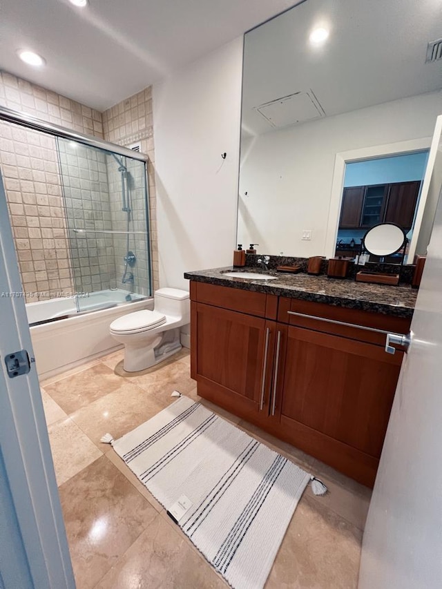 full bathroom featuring vanity, enclosed tub / shower combo, and toilet