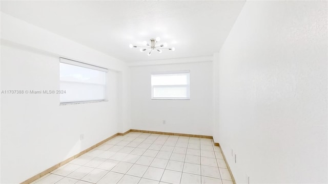 unfurnished room featuring light tile patterned floors and an inviting chandelier