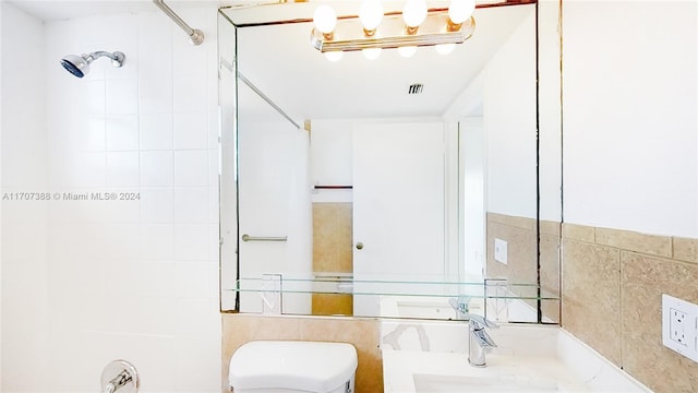 full bathroom featuring sink, tiled shower / bath combo, tile walls, and toilet