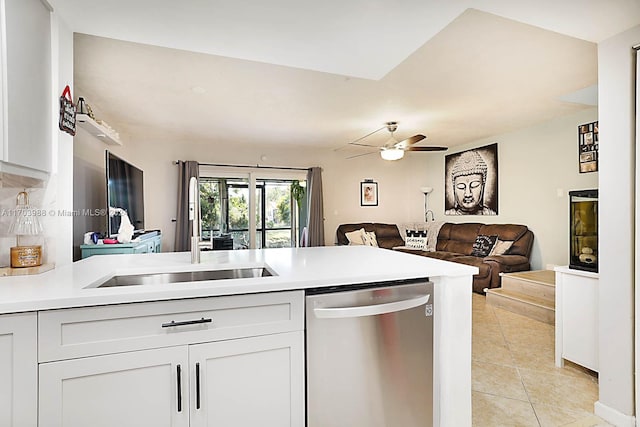 kitchen with sink, stainless steel dishwasher, ceiling fan, light tile patterned floors, and white cabinetry