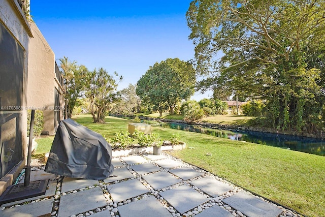 view of yard with a patio and a water view