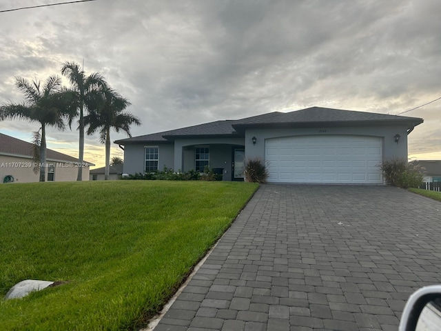 view of front of house with a yard and a garage