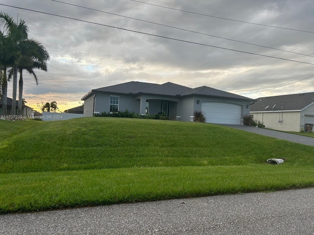 view of front of house featuring a lawn and a garage