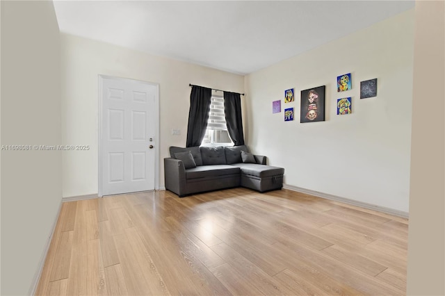 unfurnished room with baseboards and wood finished floors