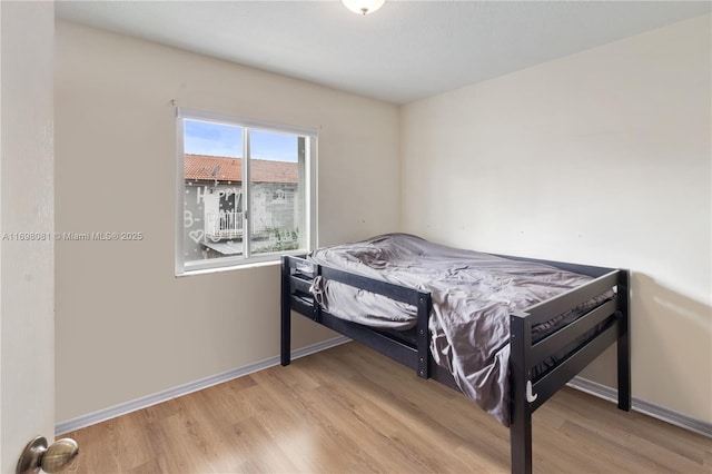 bedroom featuring light wood-type flooring and baseboards