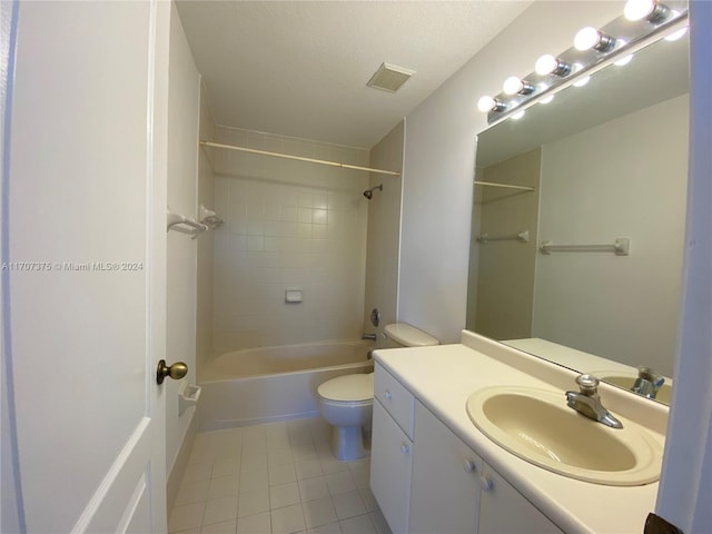 full bathroom featuring vanity, tile patterned flooring, tiled shower / bath combo, toilet, and a textured ceiling