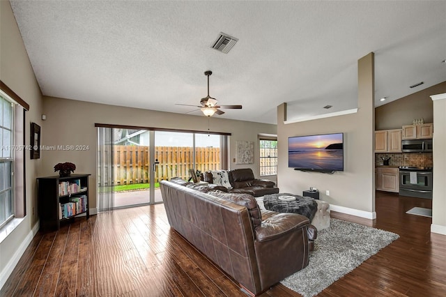 living room with a textured ceiling, dark hardwood / wood-style floors, ceiling fan, and lofted ceiling