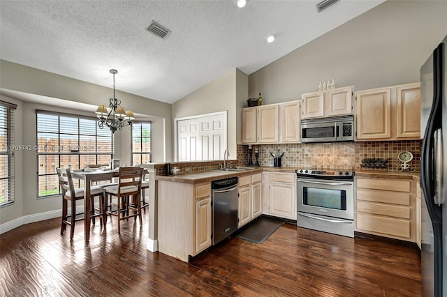 kitchen with stainless steel appliances, tasteful backsplash, dark wood-type flooring, and a notable chandelier