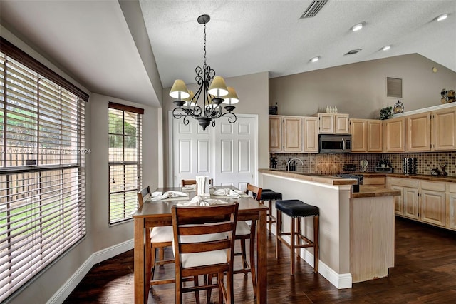 dining space with a textured ceiling, dark hardwood / wood-style floors, vaulted ceiling, and a notable chandelier