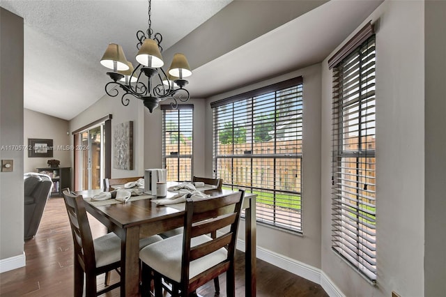 dining space featuring a chandelier, wood-type flooring, a textured ceiling, and vaulted ceiling