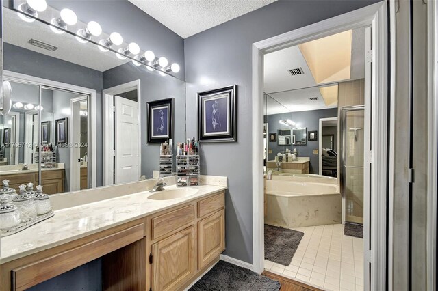 bathroom with tile patterned flooring, vanity, a textured ceiling, and shower with separate bathtub